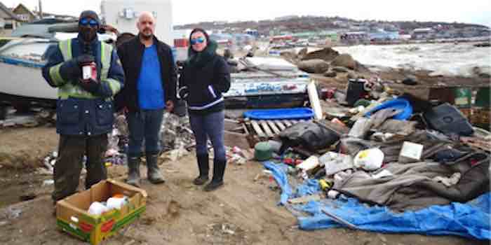 Everton Lewis holds a coffee container that Jayko Langer and Linda Shaimaiyuk delivered to him, with other foodstuffs, at the abandoned boat where he lives on the beach in Iqaluit