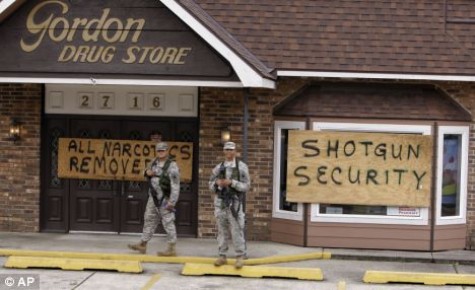 Louisiana National Guard soldiers stand guard outside a drug store