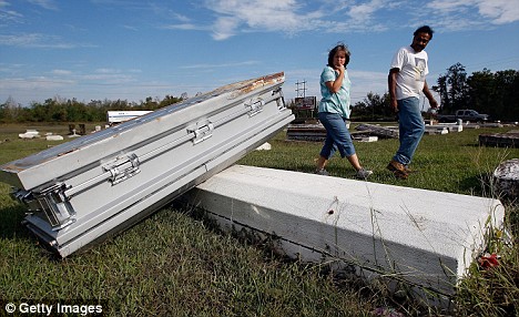 Kelly Rochelle and Danny Kelley look for the coffins belonging to Kelley's parents that floated away from their graves as a result of the storm surge