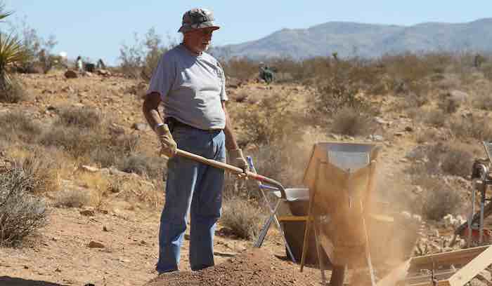 A gold prospector operates a drywasher at the outing